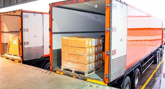 Car trailer with cargo, orange truck trailer, transport vehicle, logistics, freight transportation, vehicle setup, industrial trailer, cargo delivery, vehicle accessories, trucking equipment.