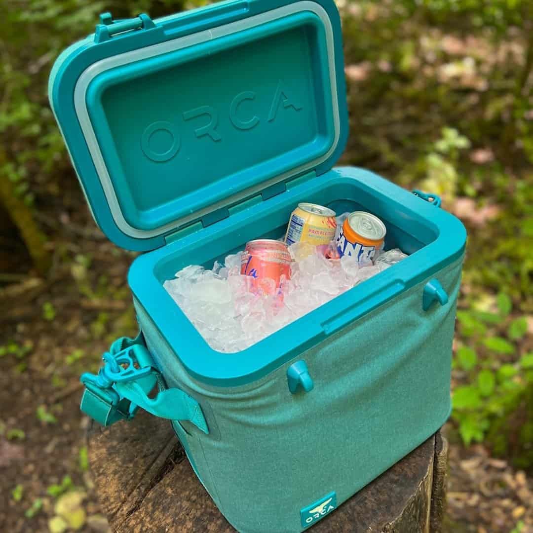 Cooler with ice and soda cans for car trips, outdoor adventures, and camping. Keeps drinks cold and fresh on the go.
