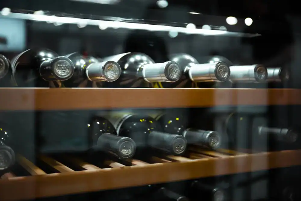 Wine bottles stored in a wine cooler or wine fridge.