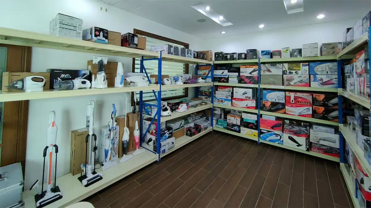 Organized shelves showcasing car and home tools, including vacuum cleaners, air pumps, and compact appliances in a well-lit room.