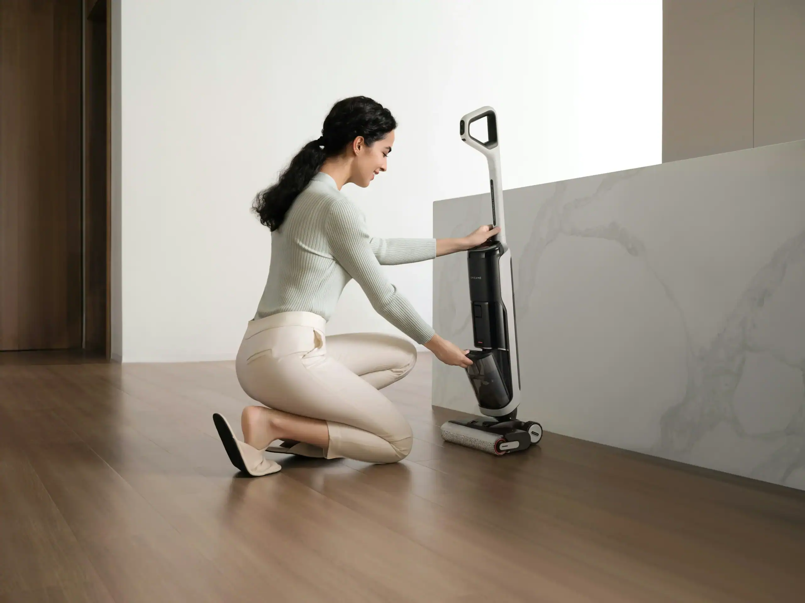 Woman using KelyLands cordless vacuum cleaner for car cleaning.