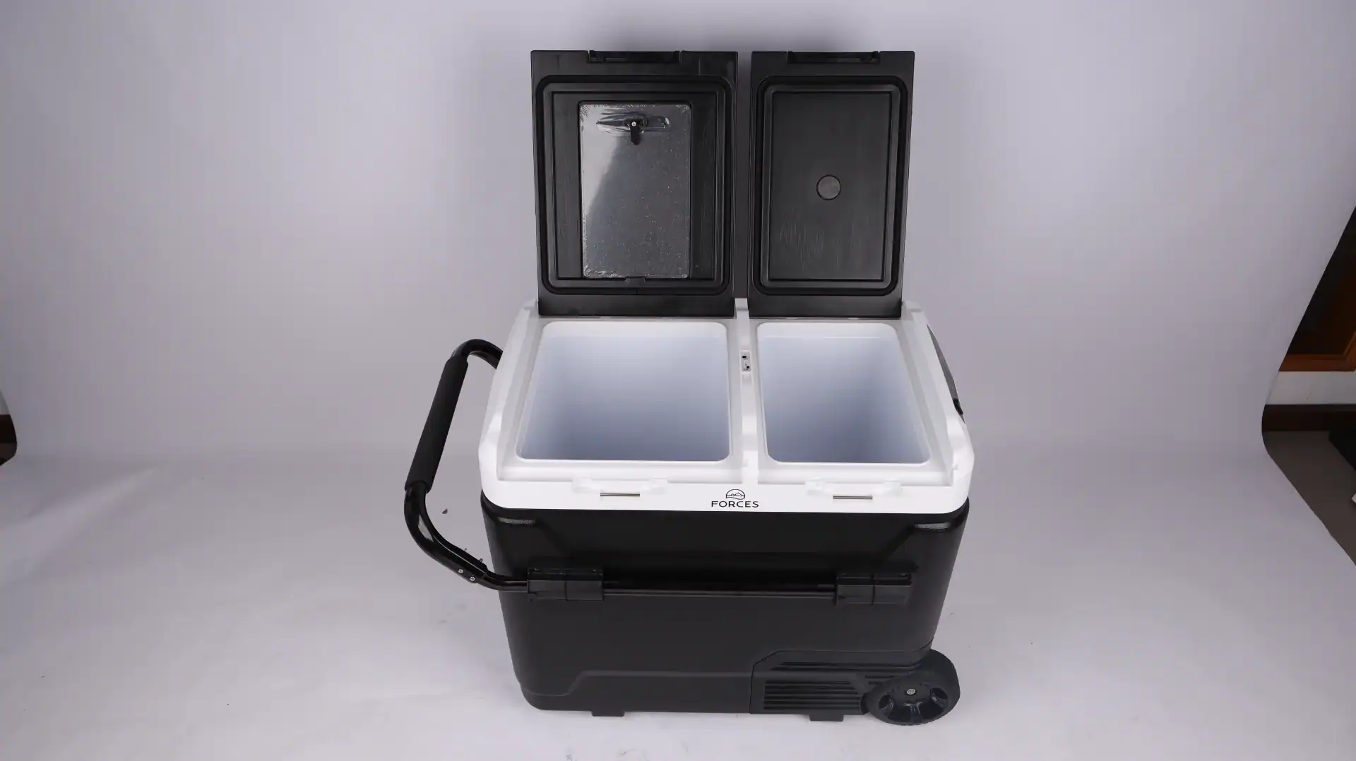 Dual-compartment portable car cooler fridge with black body, white interior, and wheels, open lids showing compartment space.