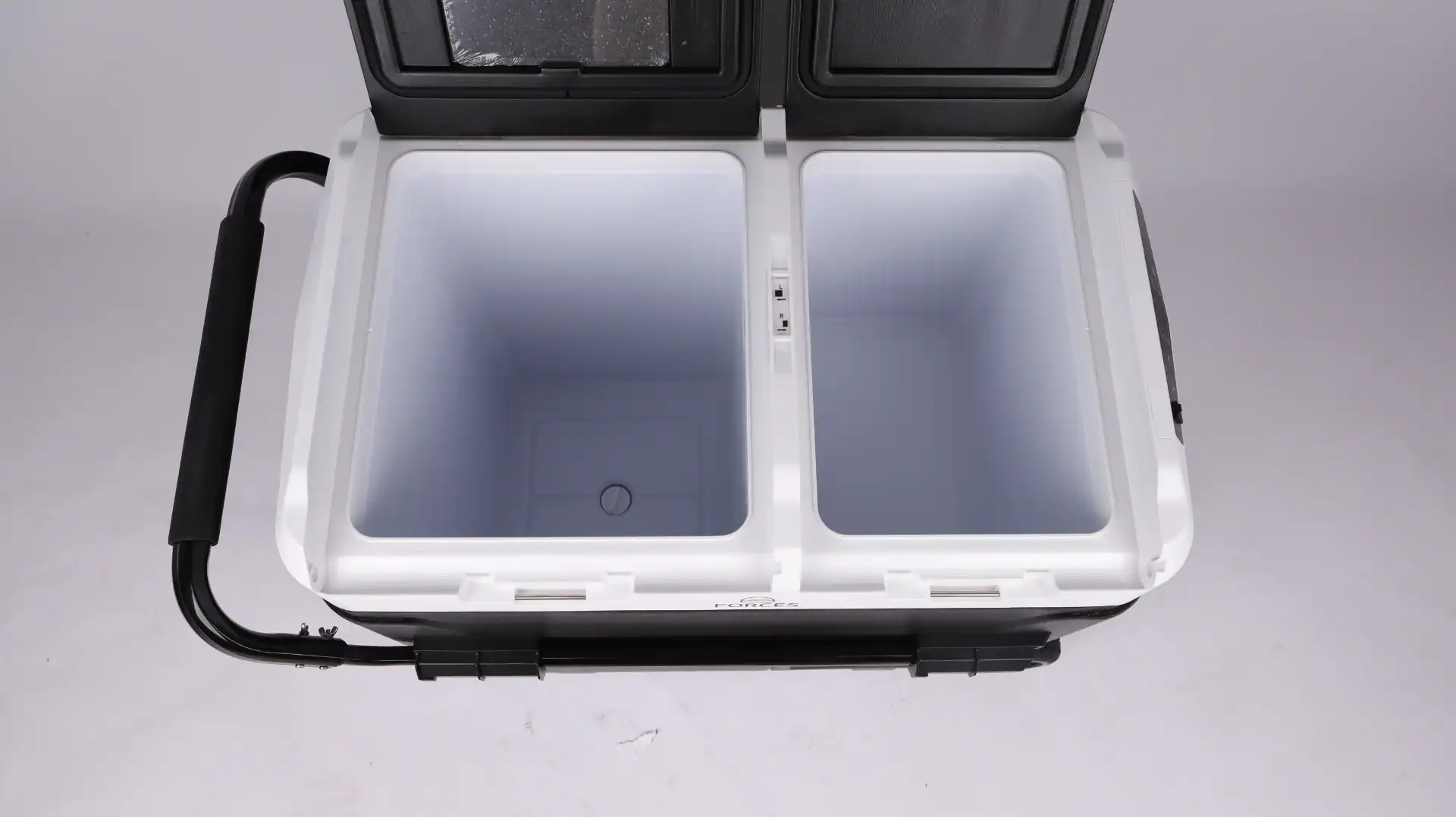 Top view of a dual-compartment car fridge with open lid, showing two empty insulated compartments and a black handle.