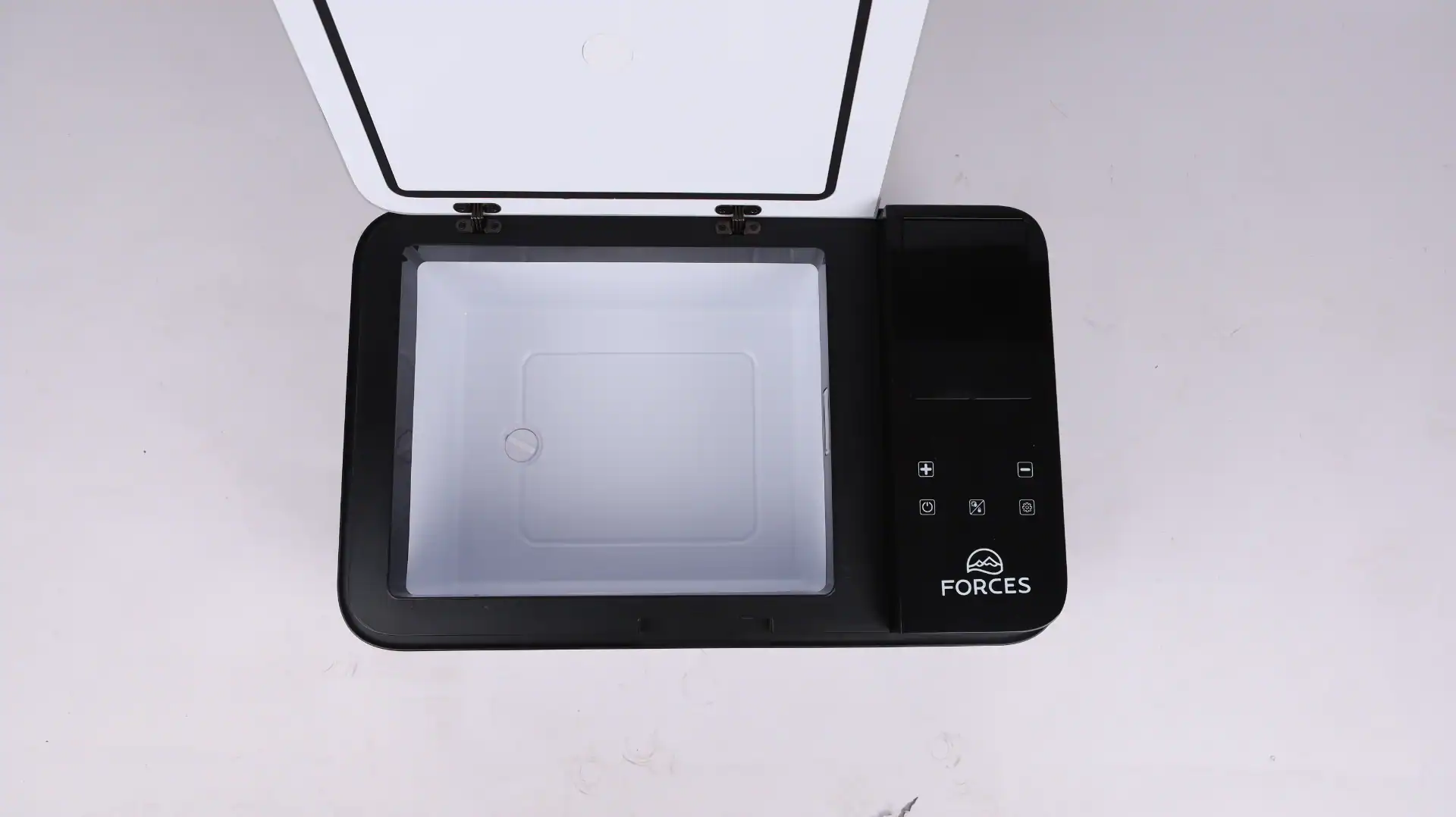Top view of an open portable car fridge with a white interior compartment and touchscreen controls on the black lid.