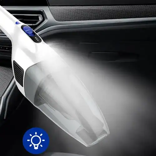 A white handheld portable vacuum cleaner being used to clean the interior of a car, showcasing its powerful suction and sleek design.