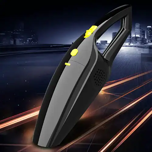 Compact portable car vacuum cleaner with yellow buttons and black body, set against a vibrant city night background with light trails.