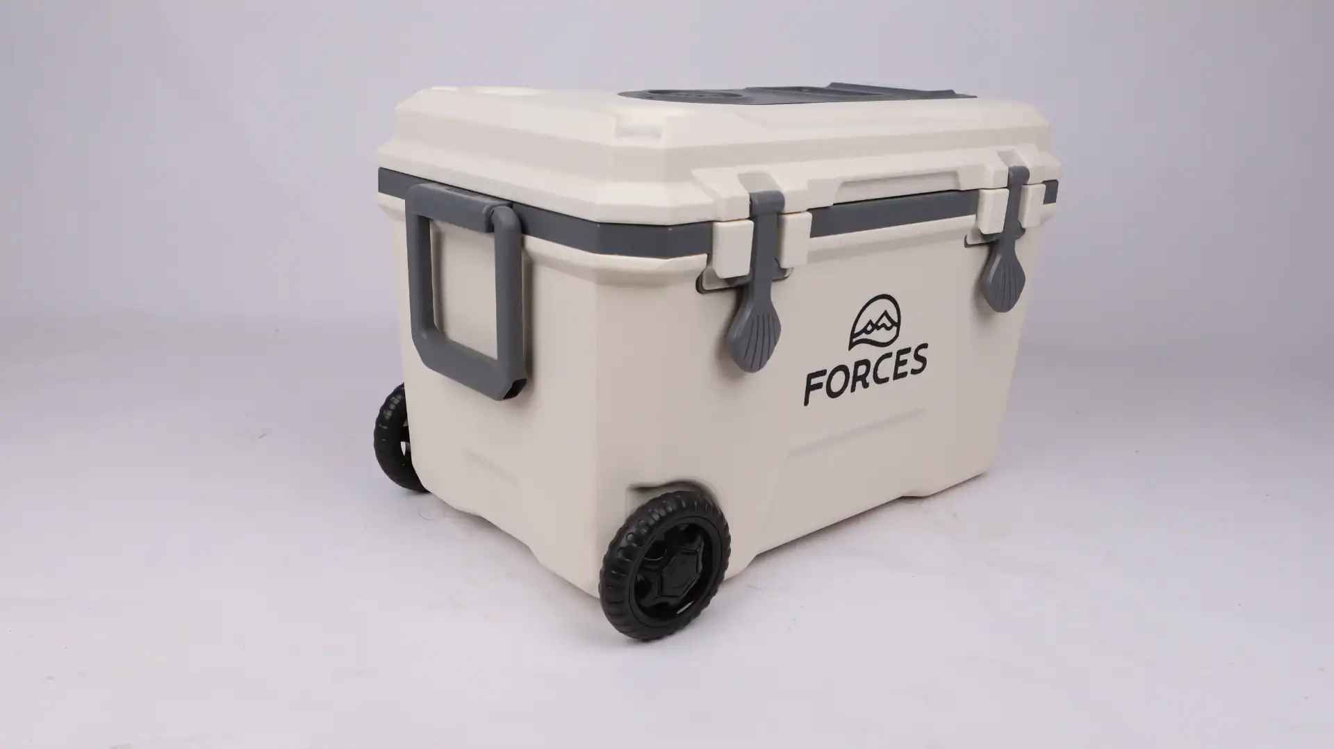 Beige portable cooler box with wheels, sturdy handles, secure latches, and 'Forces' branding, placed against a white background.