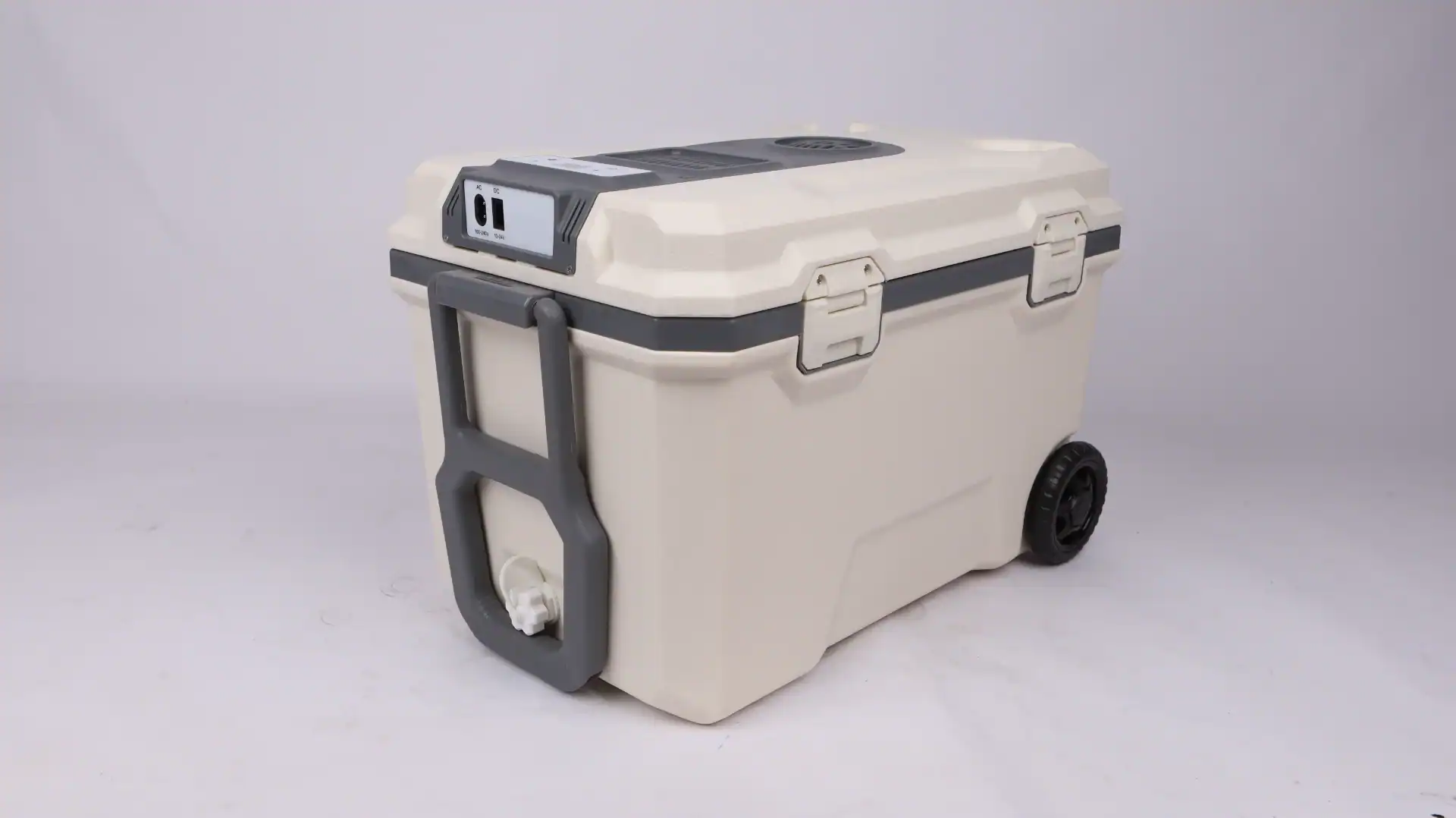 A beige and gray portable car fridge with wheels, sturdy handle, dual AC/DC power ports, and secure latches, placed on a white background.